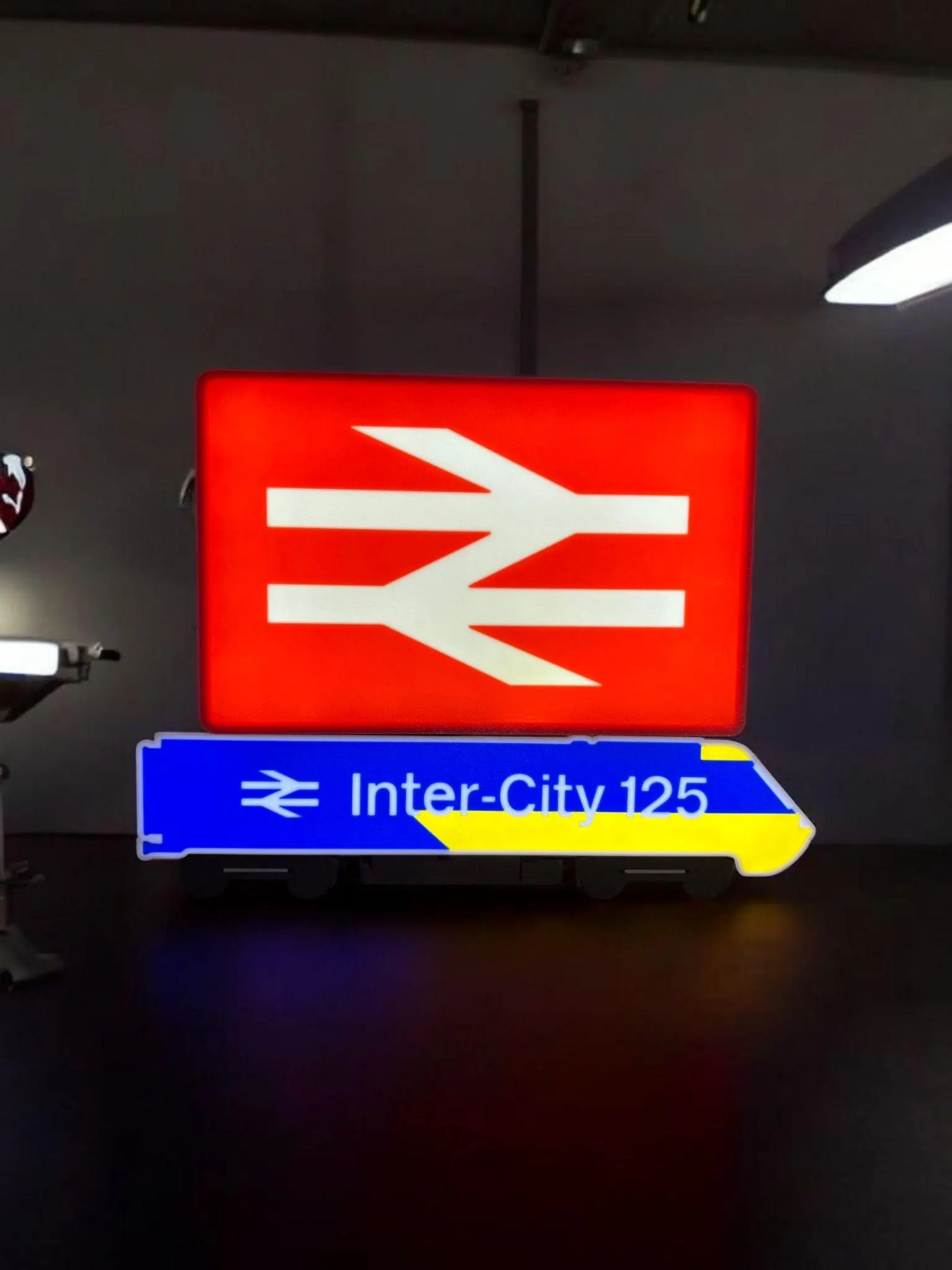 3D printed British Rail double arrow logo glowing on shelf