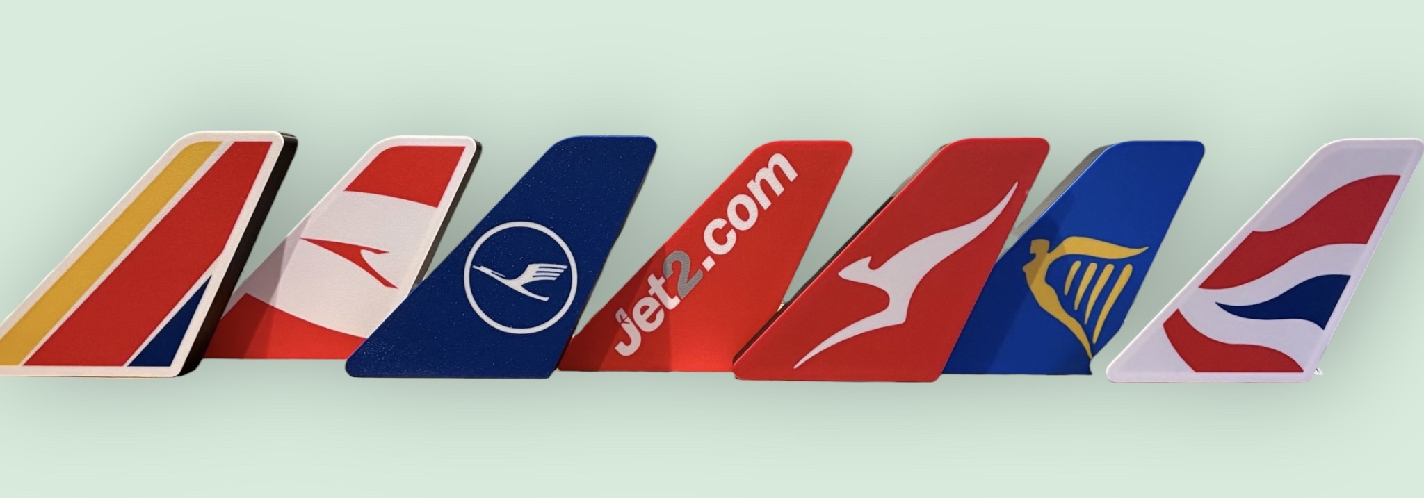 Collection of airline tail fin replicas lined up showing different liveries